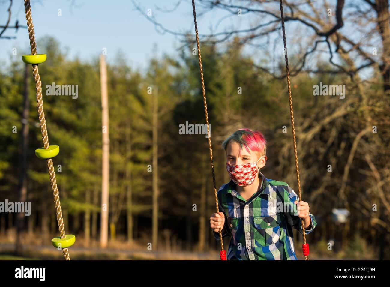 Kanada, Ontario, Junge in Gesichtsmaske auf Schaukel Stockfoto