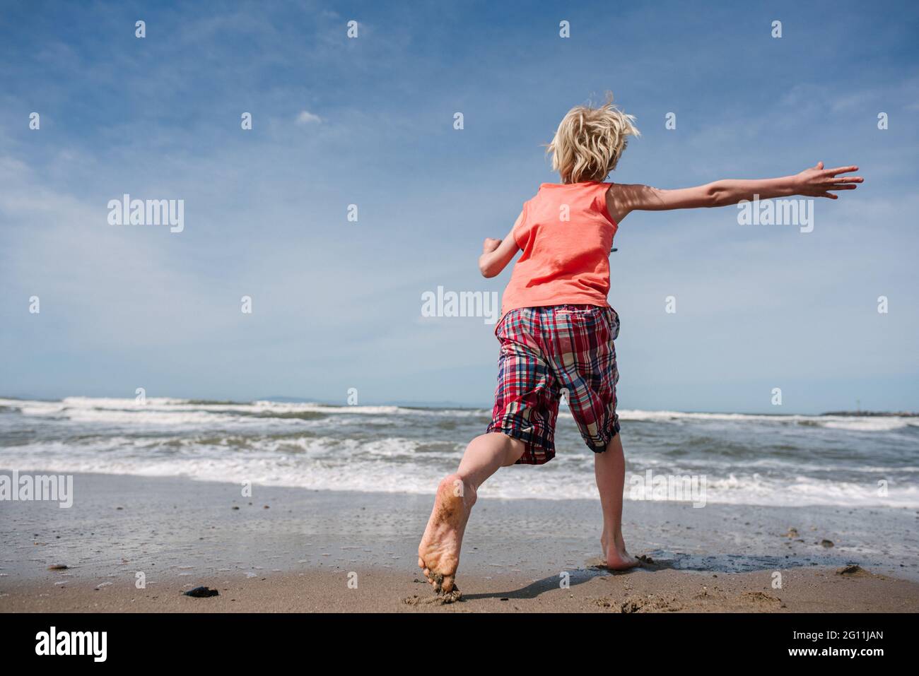 USA, Kalifornien, Ventura, Rückansicht des Jungen, der am Strand läuft Stockfoto