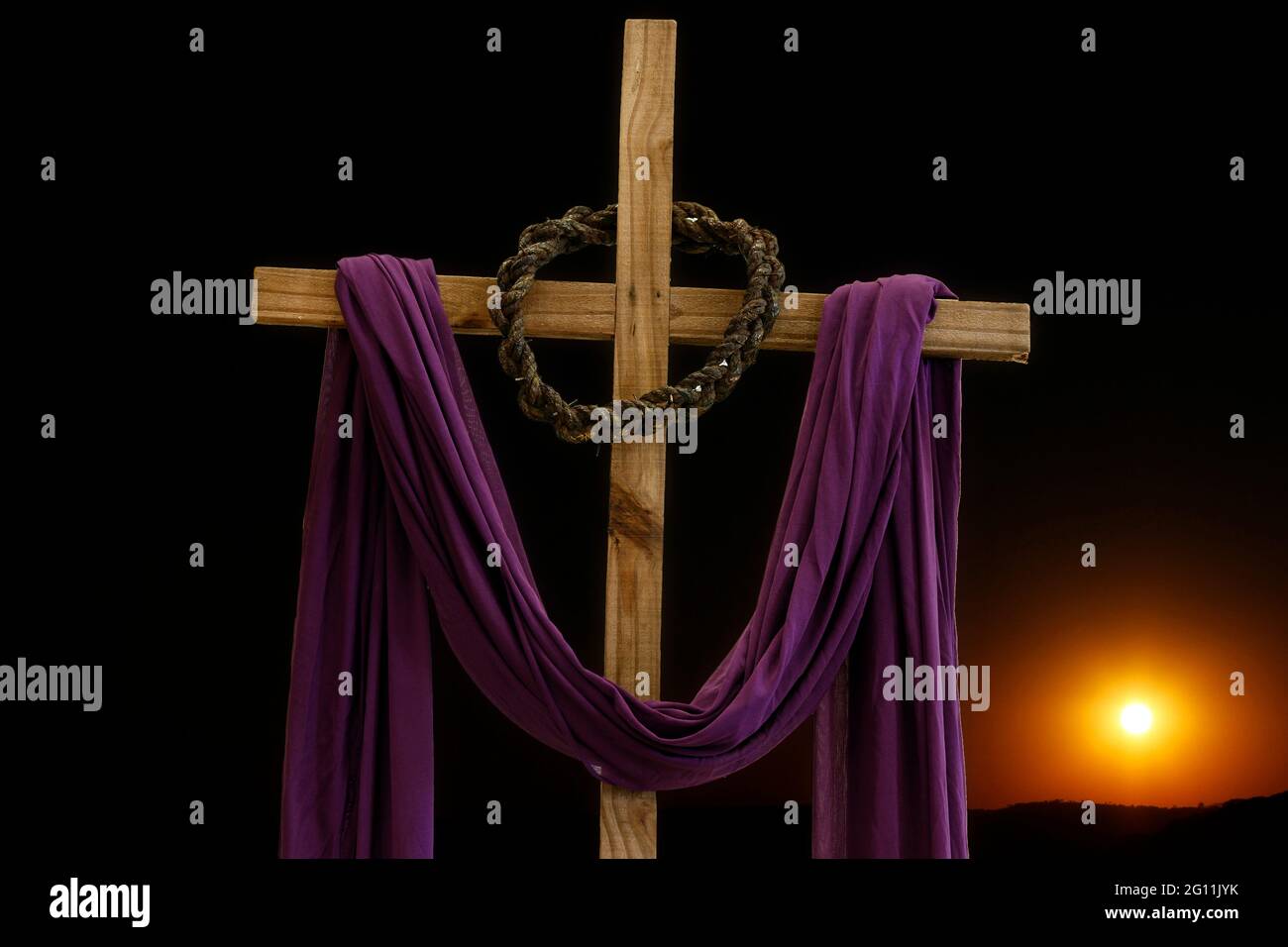 Holzkreuz mit Dornenkrone und violettem Stoff, katholische Symbole, Zeit der Fastenzeit Stockfoto