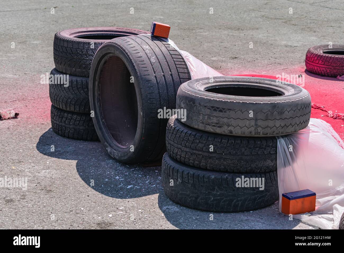 Alte abgenutzte Autoreifen, die zur Sicherheit bei Unfällen auf der Rennstrecke gefaltet und mit Polyethylen bedeckt sind Stockfoto