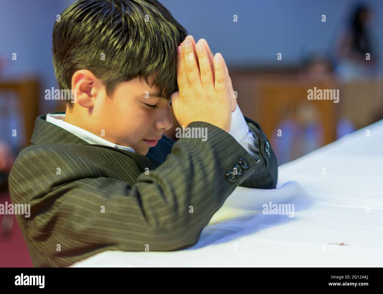 Kind, der in einer katholischen Kirche betet (keine Freilassung verfügbar) Stockfoto