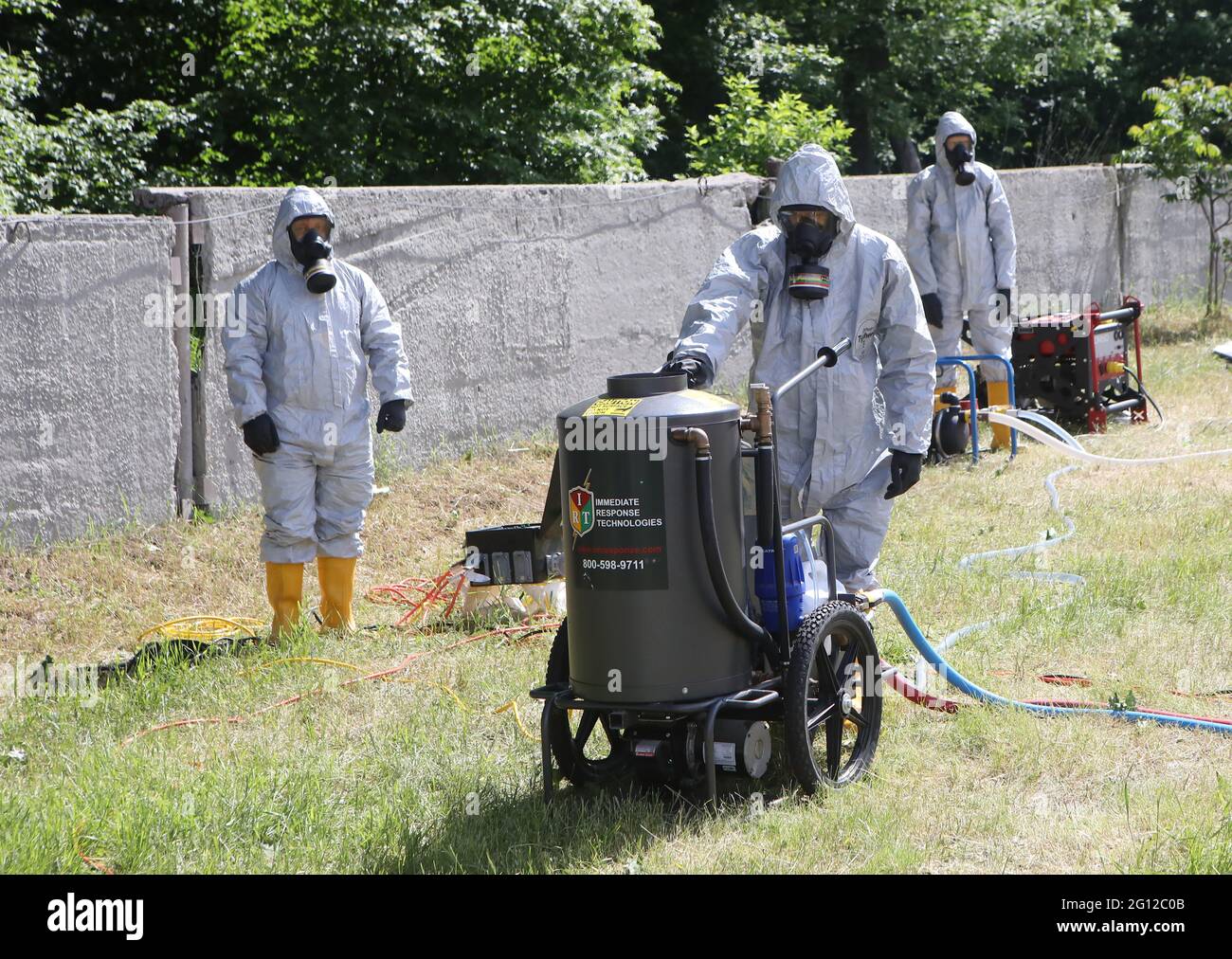 HAI, UKRAINE - 4. JUNI 2021 - EIN Retter in einem Schutzanzug und einer Gasmaske schiebt während der Spezialübungen des ukrainischen Staatlichen Notdienstes auf dem Trainingsgelände des Interregionalen Krisenreaktionszentrums, Dorf Hai, Region Sumy, im Nordosten der Ukraine, ein Ausrüstungsstück. Kredit: Ukrinform/Alamy Live Nachrichten Stockfoto