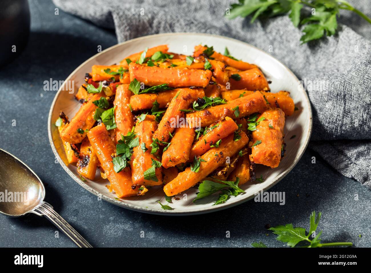 Hausgemachte Bio-Orange geröstete Karotten mit Knoblauch und Petersilie Stockfoto