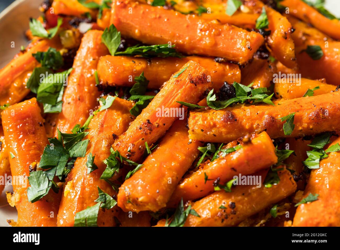 Hausgemachte Bio-Orange geröstete Karotten mit Knoblauch und Petersilie Stockfoto
