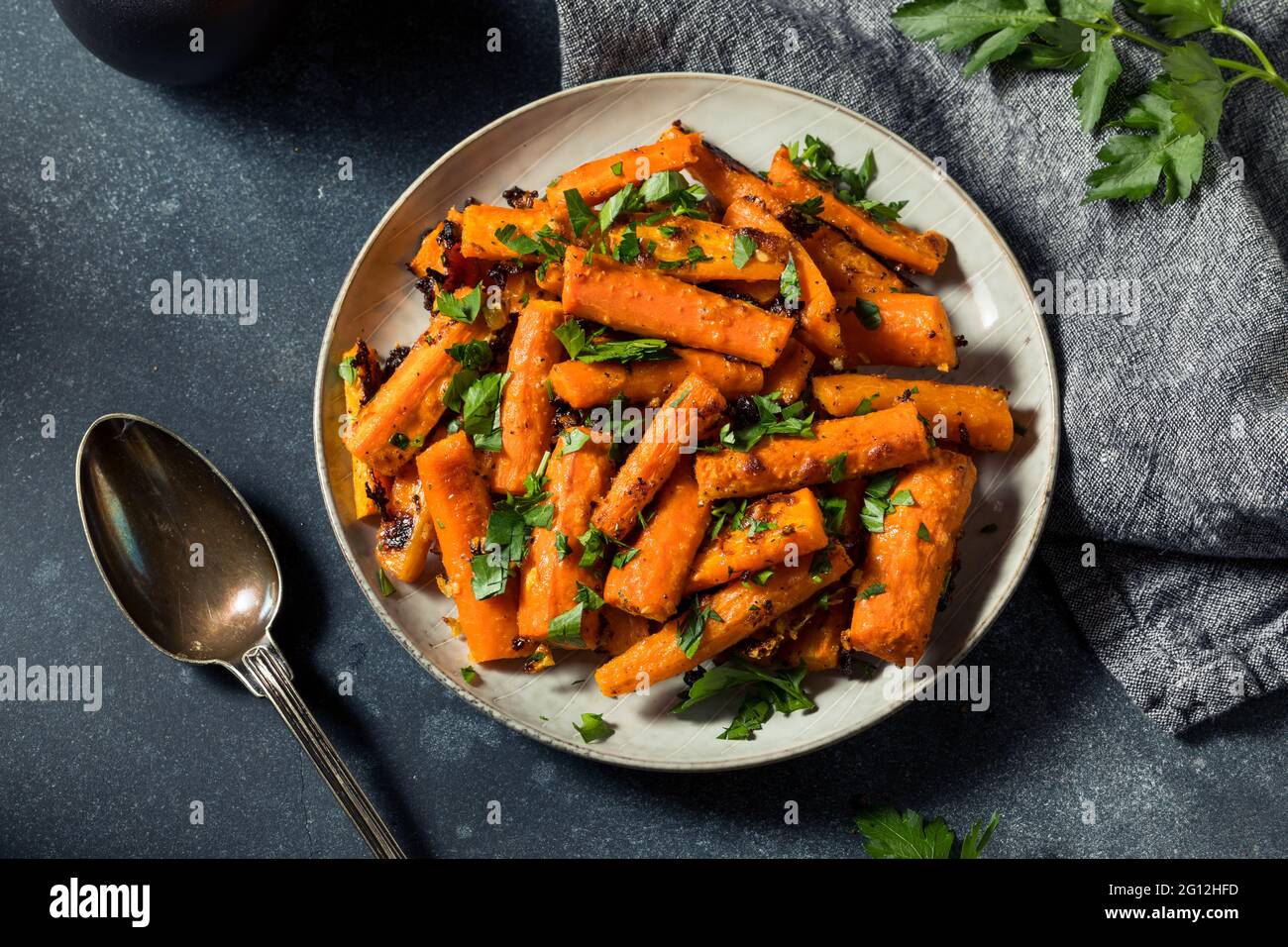 Hausgemachte Bio-Orange geröstete Karotten mit Knoblauch und Petersilie Stockfoto