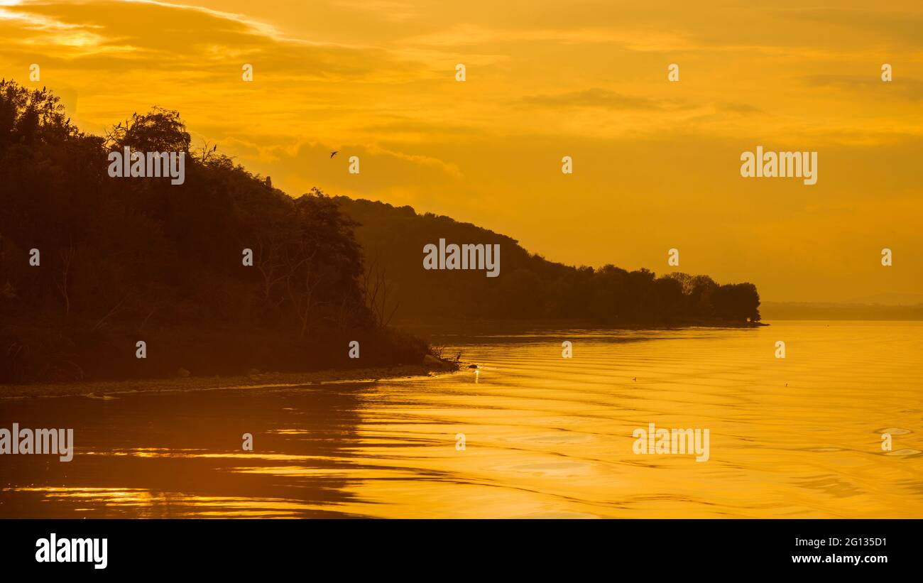 Goldenes Abendlicht über dem Trasimenischen See Isola Maggiore (Großinsel) und Isola Minore (kleine Insel) mit Kormoranen in Umbrien Stockfoto