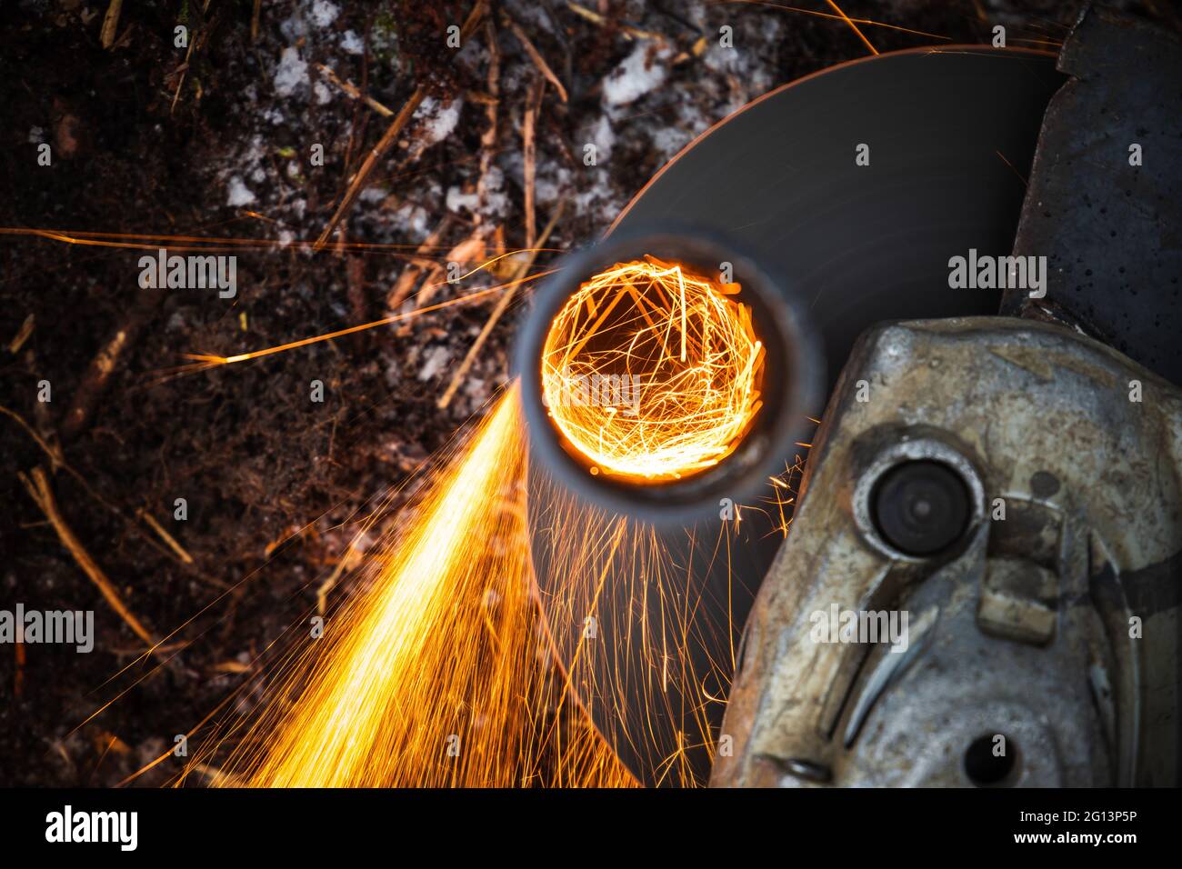 Winkelschleifer Maschine Schneiden Metallrohr mit hellen Funkenstrahl, Draufsicht, Nahaufnahme Foto mit selektivem Fokus Stockfoto