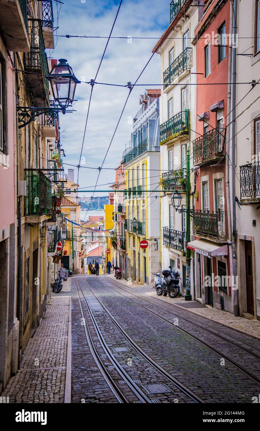 LISSABON, PORTUGAL - 25. MÄRZ 2017: Typische Straße des Stadtzentrums von Lissabon mit alten Gebäuden, Restaurants und Straßenbahnschienen Stockfoto