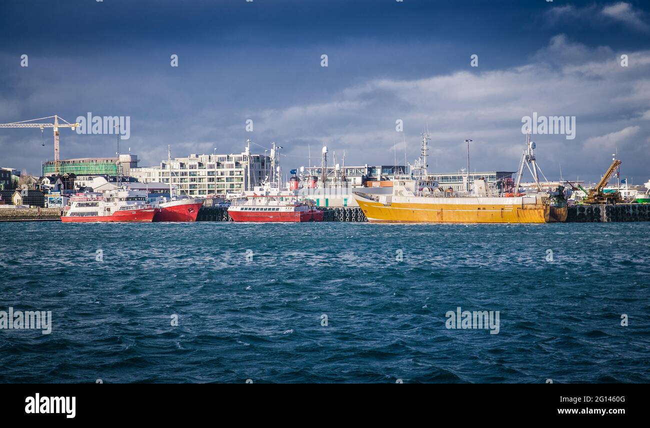 Reykjavic , Island- 20. Feb 2020: Schiffe im Seehafen von Reykjavic. Seeschiffe und Boote im Hafen bei bewölktem Himmel. Wassertransport und Seeverkehr Stockfoto