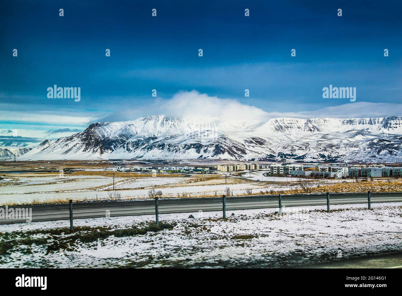 Wunderschöne isländische Winterlandschaft mit schneebedeckten Bergen und blau bewölktem Himmel. Island. Stockfoto