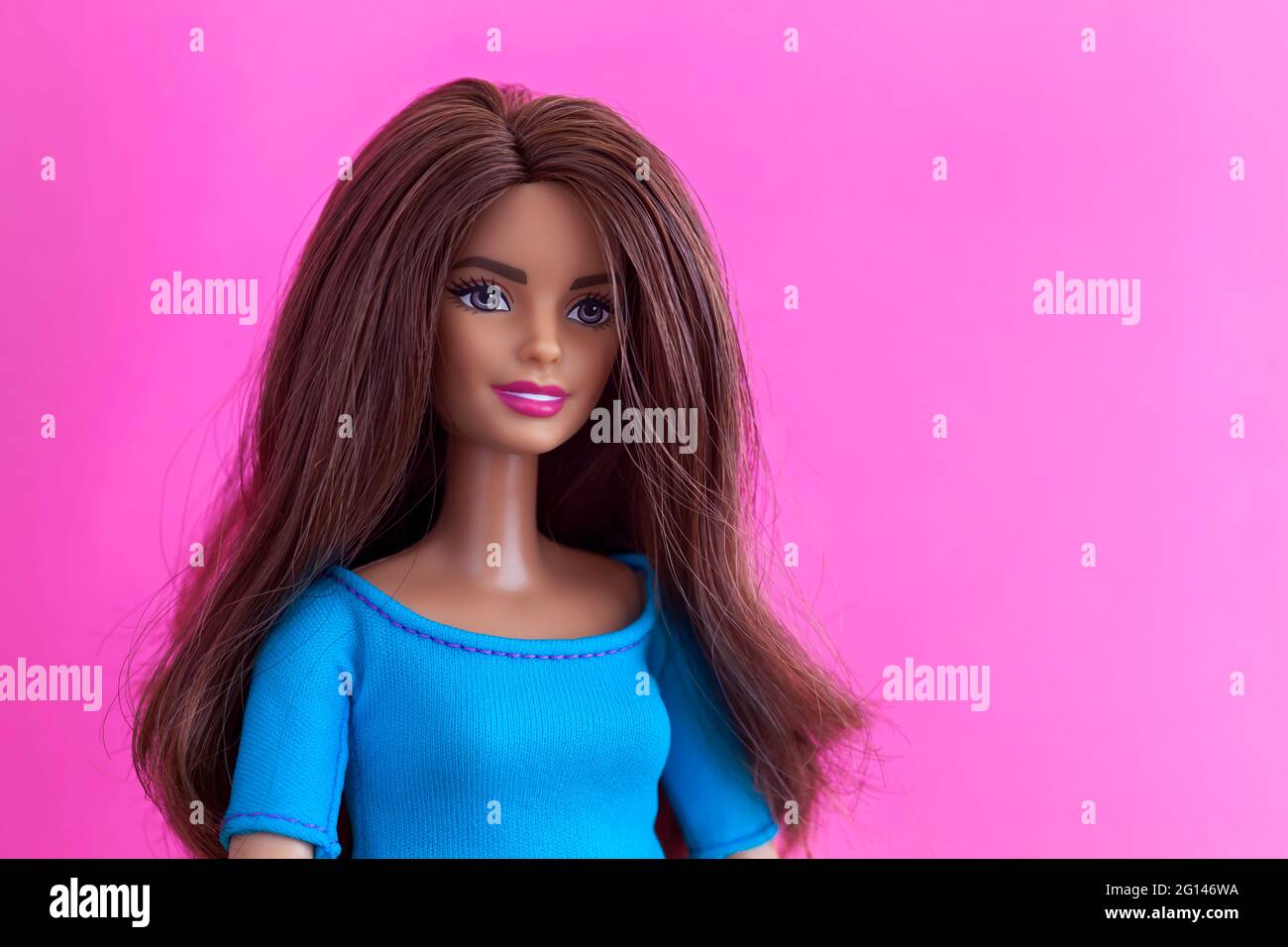 Tambow, Russische Föderation - 27. November 2018 Porträt einer brünetten Barbie-Puppe vor einem magentafarbenen Hintergrund. Stockfoto