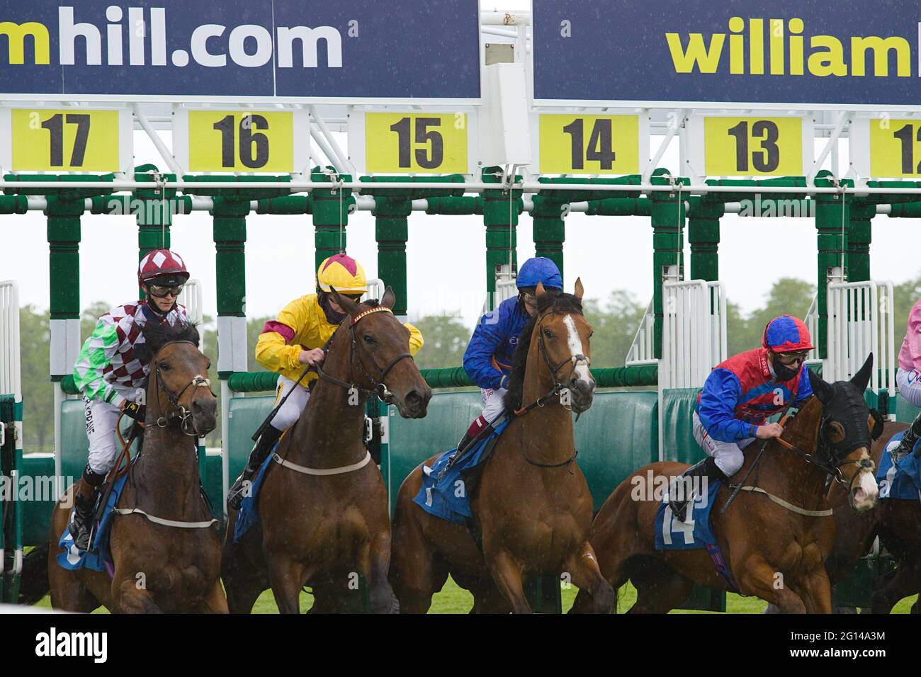 Jockeys platzten beim Start eines Rennens auf der Pferderennbahn York aus dem Starttor. Mit Sean Kirrane, nathan Evans, Cieren Fallon und Rowan Scott. Stockfoto