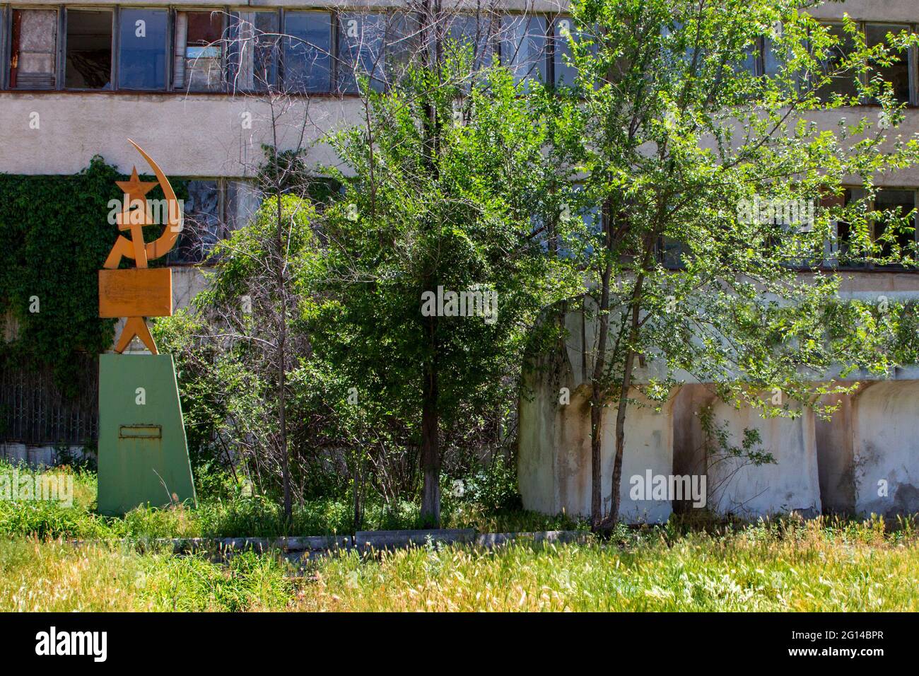 Sowjetische Symbole mit Sichel und Hammer vor einer verlassenen Glasfabrik aus der Sowjetzeit in der Nähe der Stadt Tokmok in Kirgisistan Stockfoto