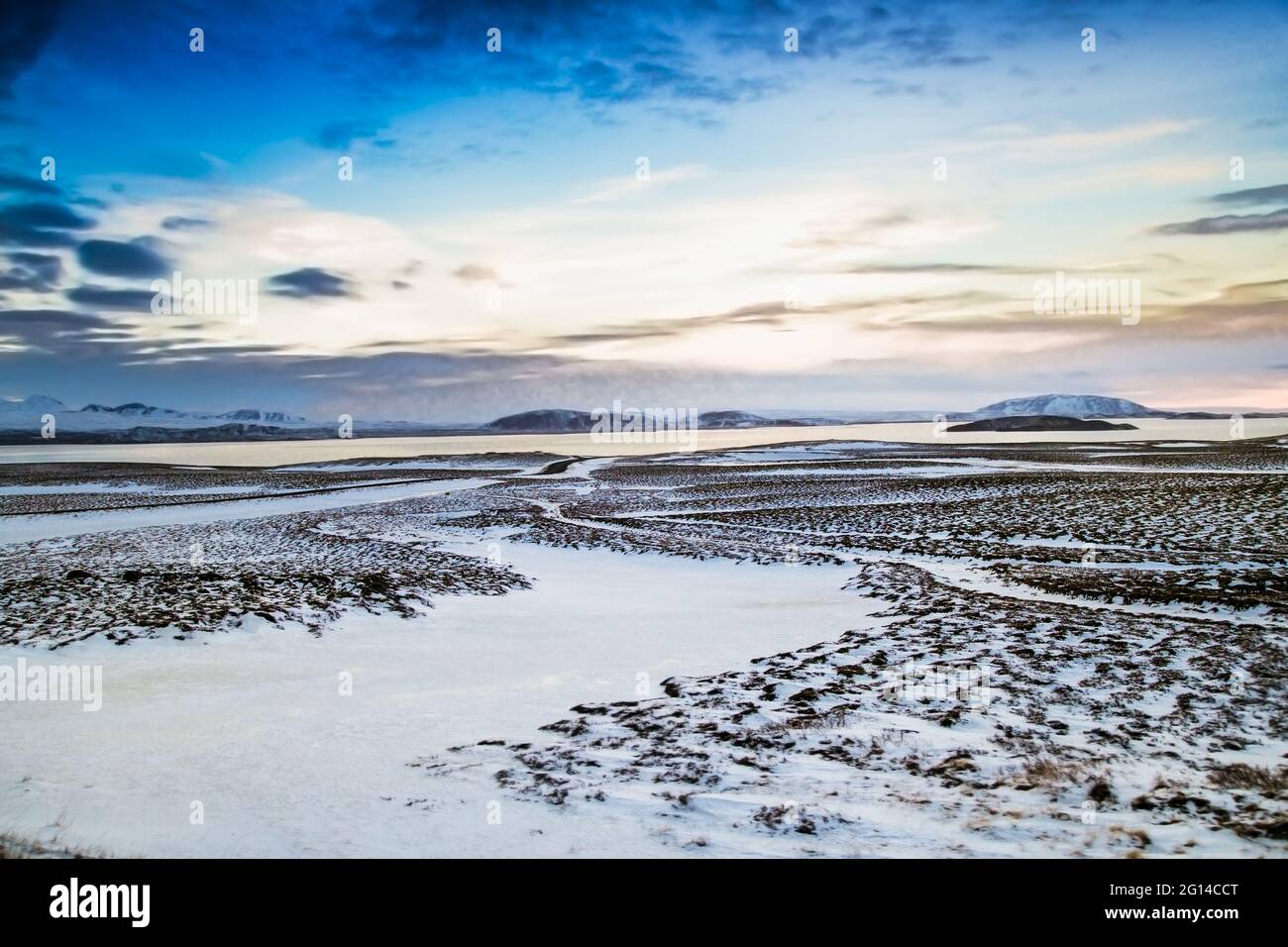 Wunderschöne isländische Winterlandschaft mit schneebedeckten Bergen und blau bewölktem Himmel. Island. Stockfoto
