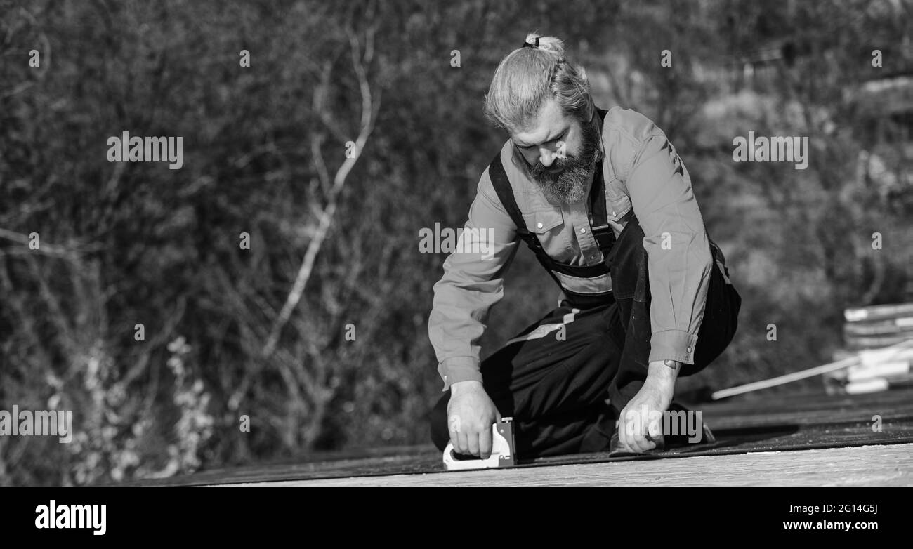 Provisorische Ausrüstung oder Strukturen montieren. Strukturelle Ummantelung. Reparieren oder erstellen. Dachdecker Reparatur Dach. Dachmontage. Bärtiger Mann arbeitet im Freien. Dach Stockfoto