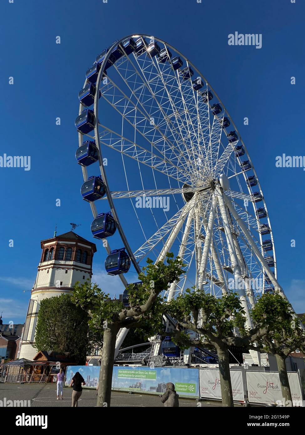 Düsseldorf, 2021 Riesenrad am Burgplatz an der Rheinpromenade neben dem Burgturm bei Sonnenuntergang. Stockfoto