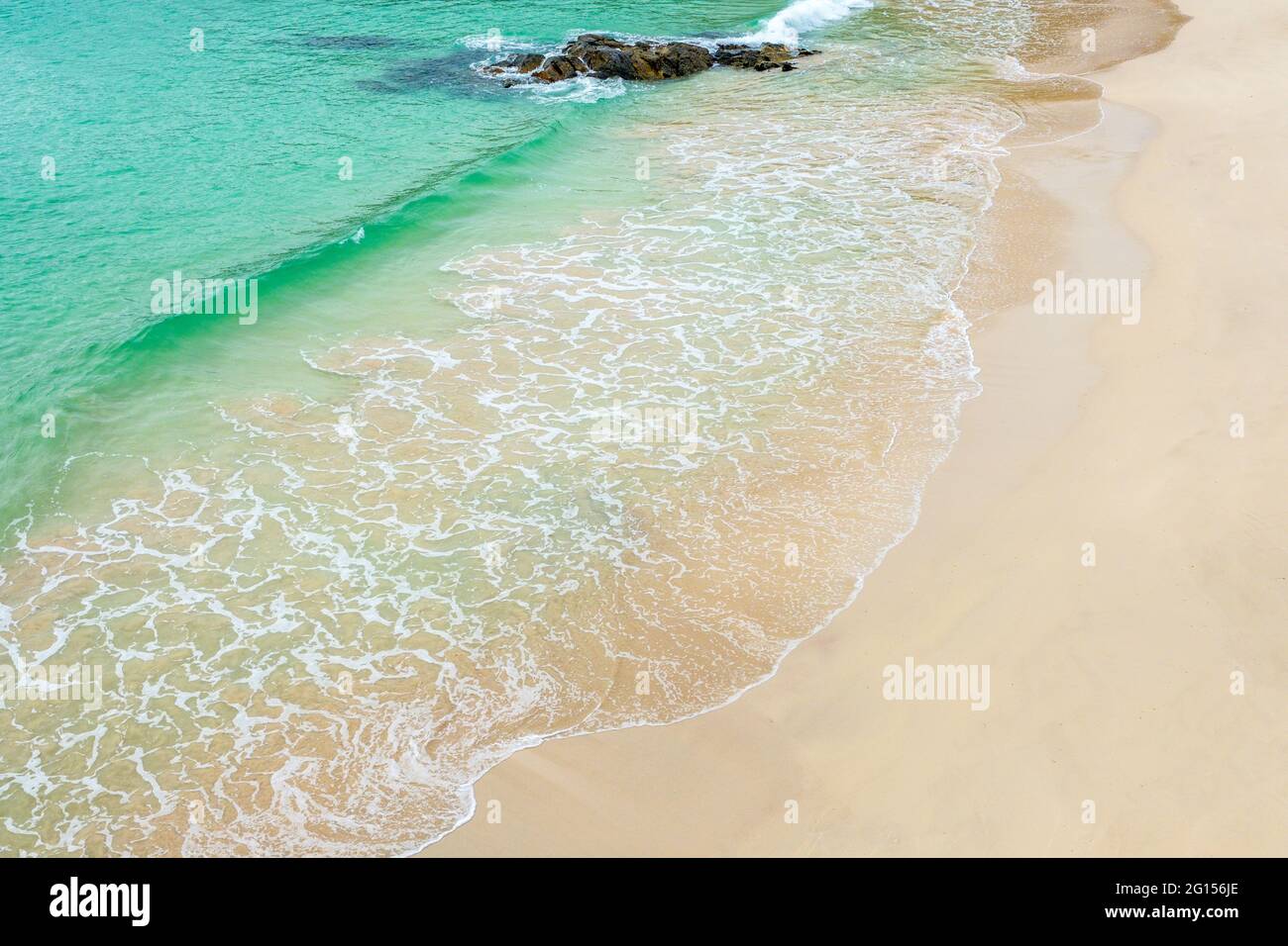 Klares Wasser, das den weißen Sand eines schottischen Strandes übertünchen kann Stockfoto