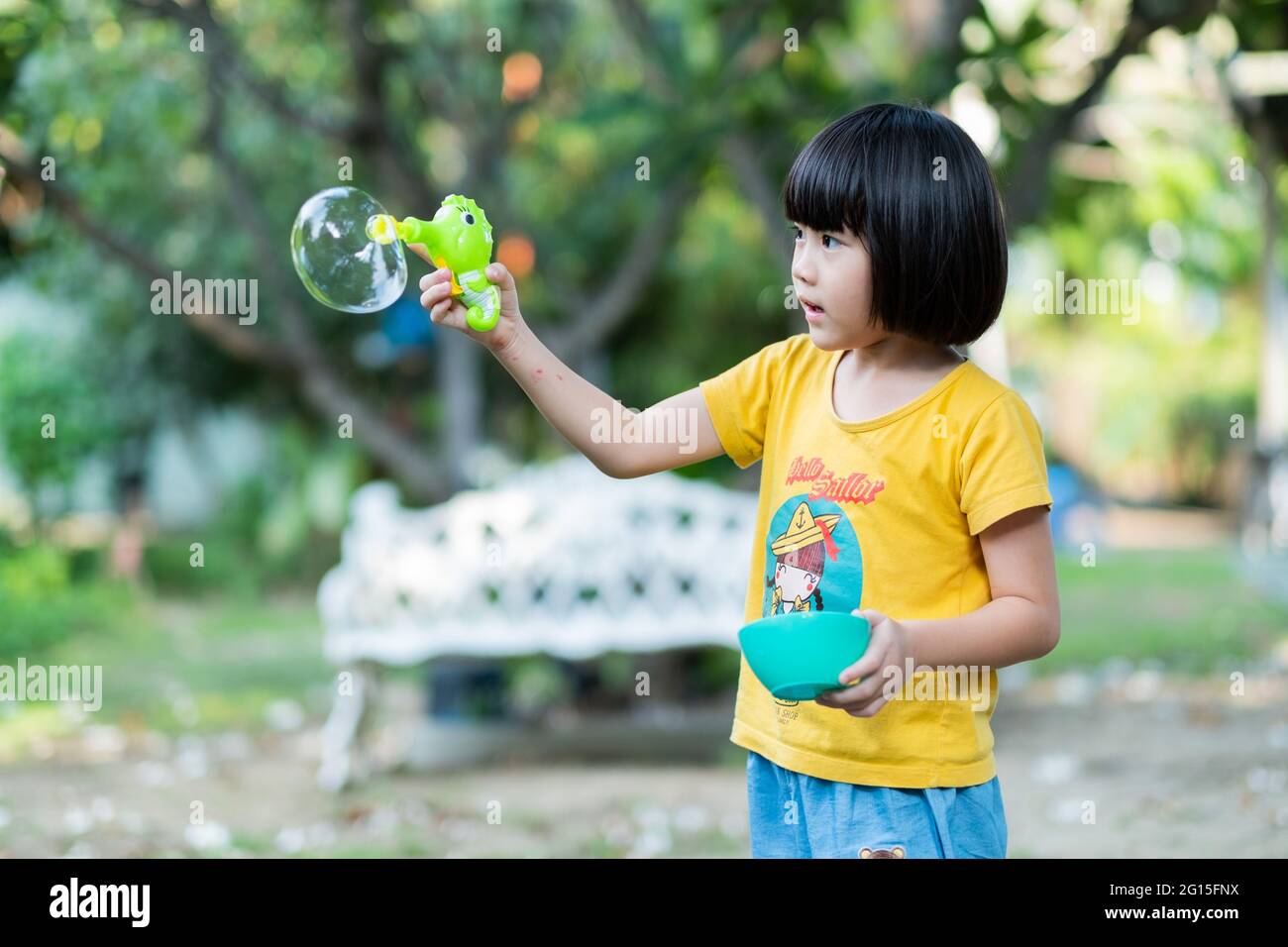asiatische chinesische Kind blasen Blase mit unscharfen Hintergrund Stockfoto
