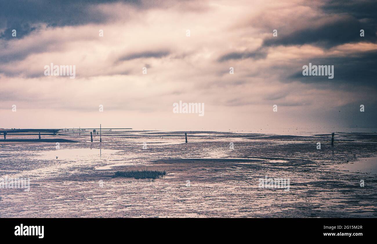 Cuxhaven Beach an der deutschen Nordseeküste. Sandstrand mit Kugelbake, einem hölzernen Leuchtturm, steht an der Mündung der Elbe in den schlammigen Schlammflächen. Stockfoto