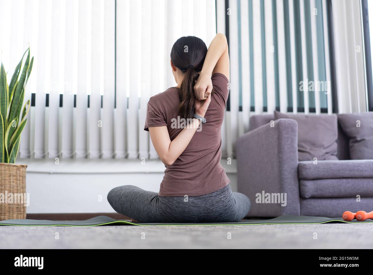 Ein ruhiges Mädchen, das ihren ganzen Körper nach dem Training mit der Spitze eines Beins ausdehnt. Stockfoto