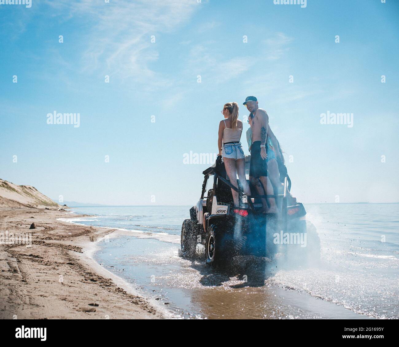 quad-Bike mit Menschen fährt am Ufer Stockfoto