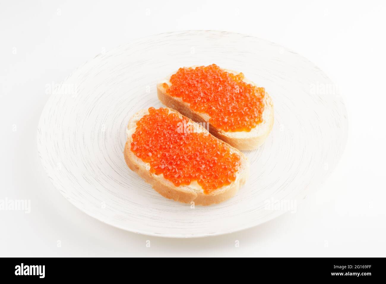 Zwei Brote mit rotem Lachsrogen auf weißem Teller Stockfoto
