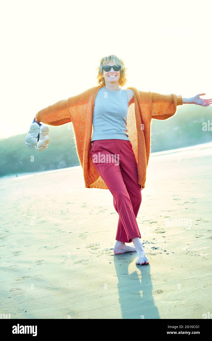 Junge reife blonde kaukasische Frau an einem sonnigen Tag draußen an einem Strand. Stockfoto