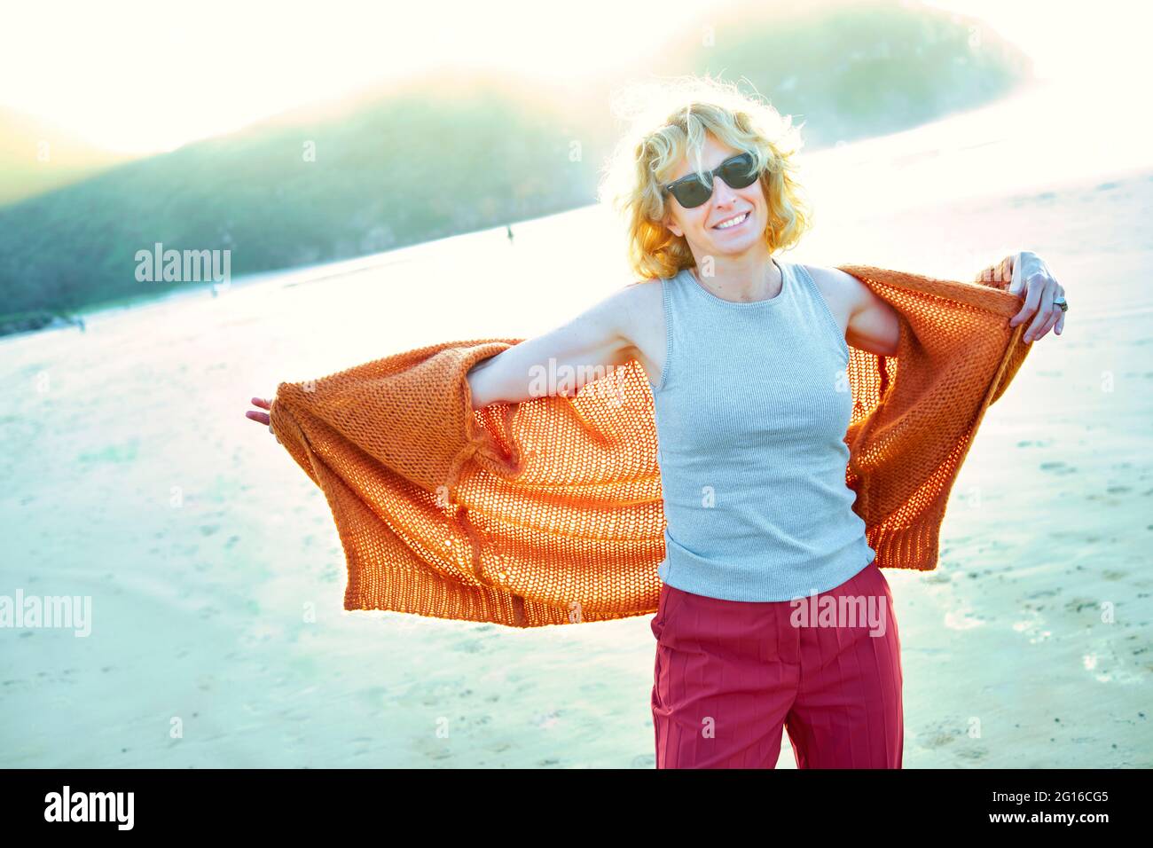 Junge reife blonde kaukasische Frau an einem sonnigen Tag draußen an einem Strand. Stockfoto