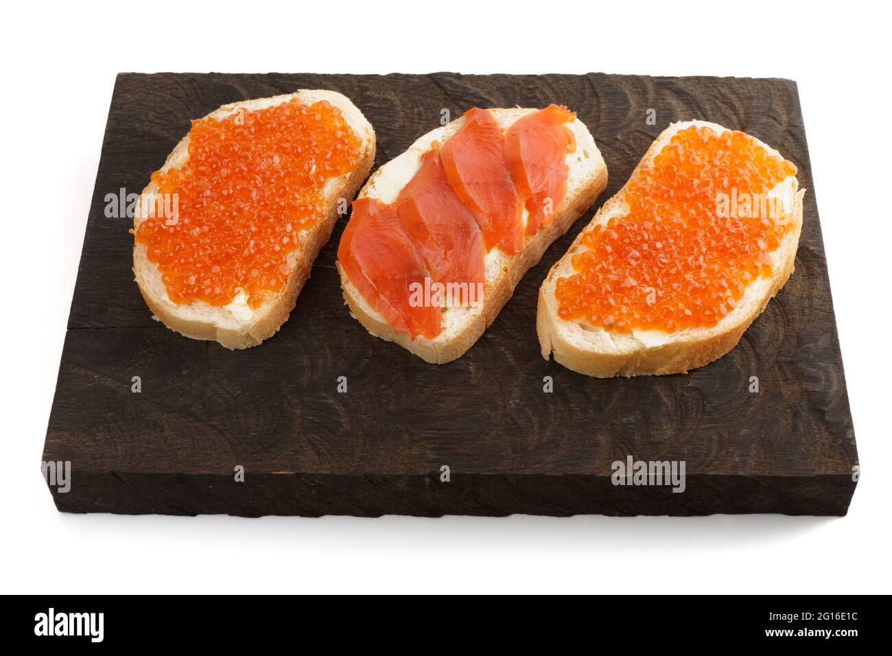 Offene Sandwiches mit Lachsrogen und Filet auf Holzbrett Stockfoto