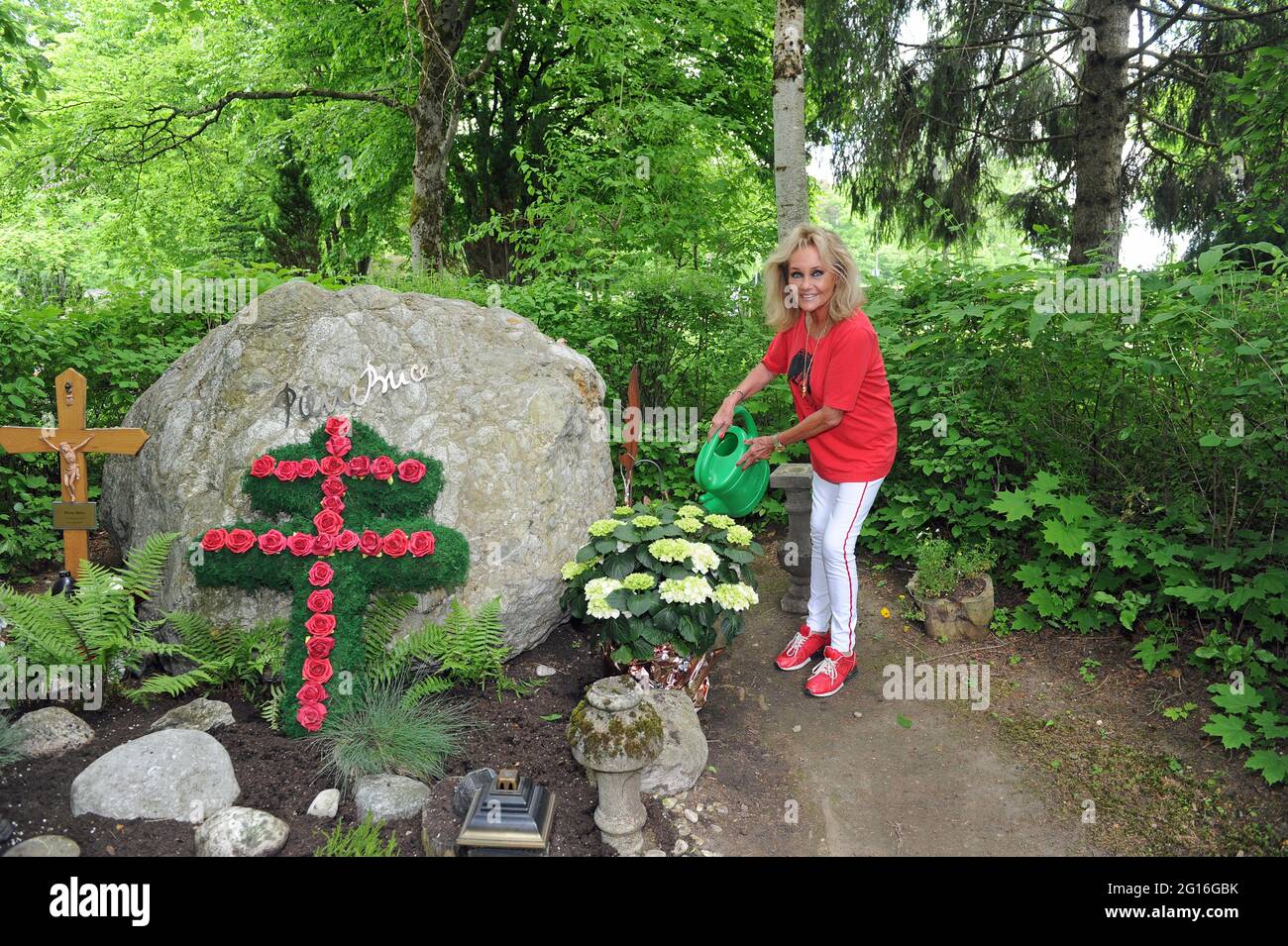 Bayern, Deutschland. Juni 2021. 04. Juni 2021, Bayern, Gräfelfing: Hella  Brice, Witwe des französischen Schauspielers Pierre Brice, bewässert Blumen  am Grab ihres Mannes. Am 6. Juni jährt sich zum sechsten Mal der