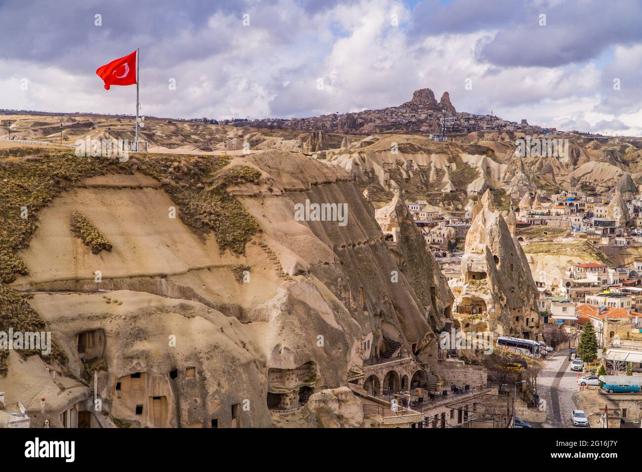 Häuser in Feenkaminen und einzigartige Felsformationen mit türkischer Flagge in Göreme, Kappadokien, Türkei Stockfoto