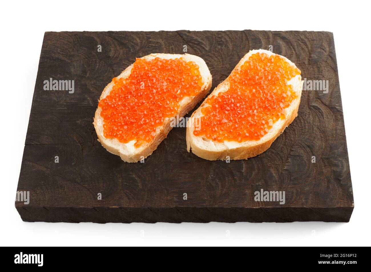 Offene Sandwiches mit Lachsrogen auf einem hölzernen Servierbrett, isoliert auf Weiß Stockfoto