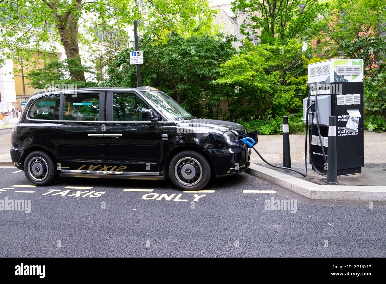 Schwarzes Londoner Taxi elektrische Wiederaufladestelle auf der Straße in der City of London Großbritannien KATHY DEWITT Stockfoto