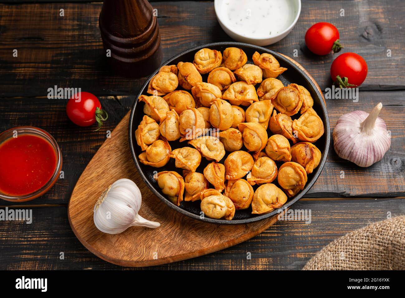 Knödel Chuchvara gebratene usbekische Küche auf Pfanne auf dunklem Holz Hintergrund Stockfoto