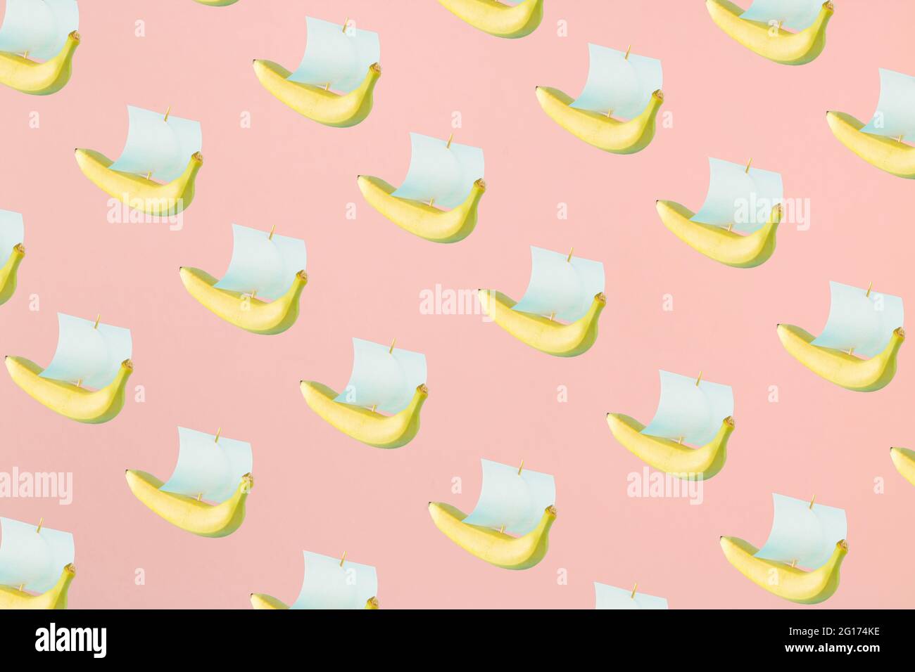 Eine gelbe Banane und ein Papier segeln wie ein Schiff auf einem pastellrosa Hintergrund. Reisen abstrakte 3D-Anzeige Hintergrund Art. Stockfoto