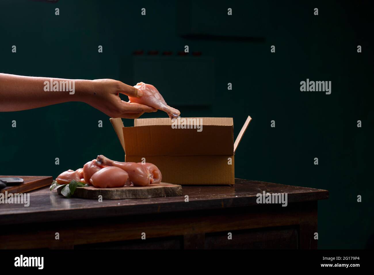 Rohes Huhn schneidet oder Teile ohne Haut auf einer Holzplatte geschnitten und ein Arbeiter Verpackung rohes Huhn für die Lieferung, die auf Holz gelegt wird angeordnet Stockfoto