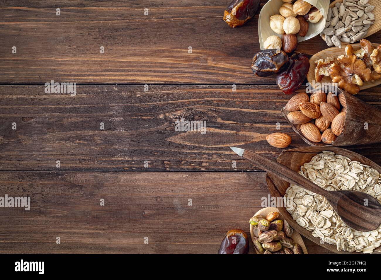 Vielzahl von Körnern und gemischten Nüssen in Bio-Platten, auf Holz braun Hintergrund, Draufsicht mit Kopierraum Stockfoto