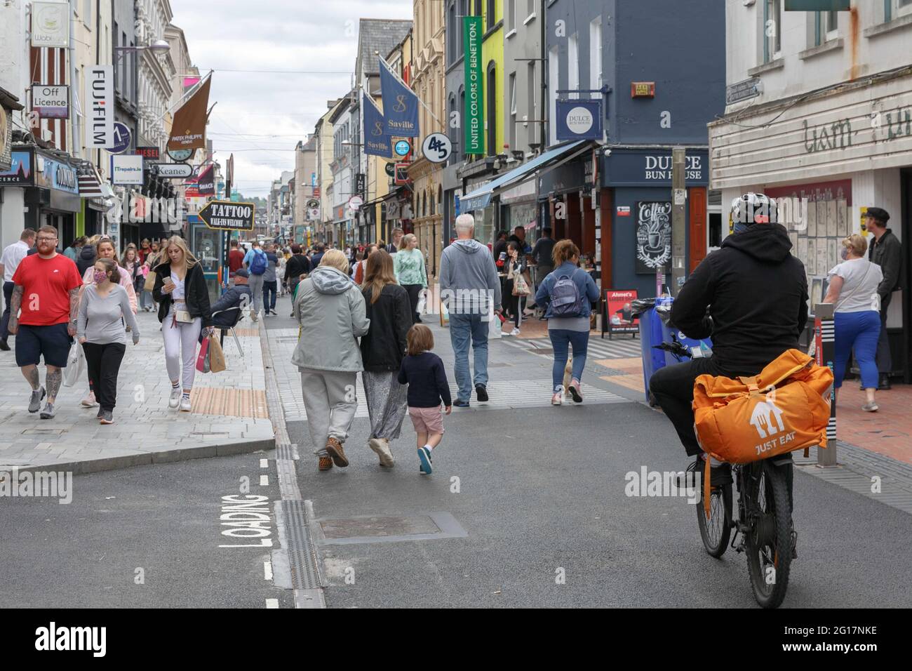 Cork, Irland. Juni 2021. Hunderte reisen bei warmem Wetter nach Cork, Irland. Hunderte von Einkäufern sind heute nach Cork gekommen, um die Sonne und die Atmosphäre in der ganzen Stadt zu genießen. Vor den meisten Geschäften, Restaurants und Cafés waren große Schlangen zu sehen. Kredit: Damian Coleman/Alamy Live Nachrichten Stockfoto