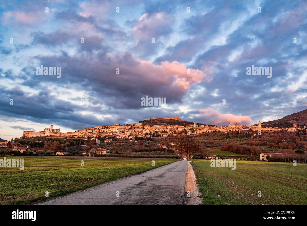 Panorama von Assisi, Stadt San Francesco, Perugia, Umbrien, grünes Herz Italiens. Der schöne Himmel mit Wolken und die Straße im Vordergrund Stockfoto