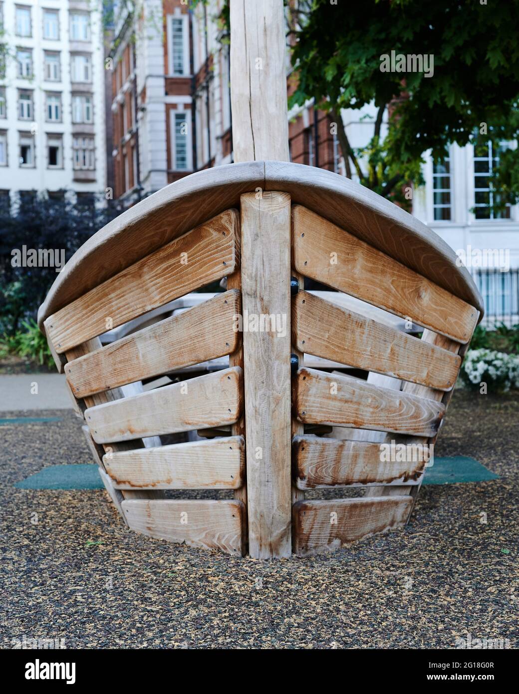 Vorderansicht eines kleinen, bootförmigen Klettergerüstes für Kinder auf einem Spielplatz in einer Stadt Stockfoto