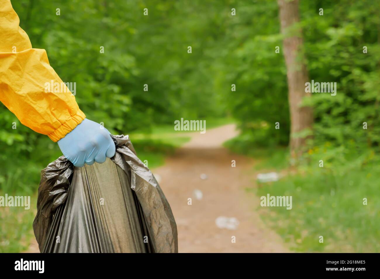 Freiwillige Reinigung Müll einen Park. Die Menschen kümmern sich um die Verschmutzung der Erde Plastikmüll Arbeiter Hand hält Müllbeutel. Freiwillige Hände nehmen einen Kunststoff auf Stockfoto