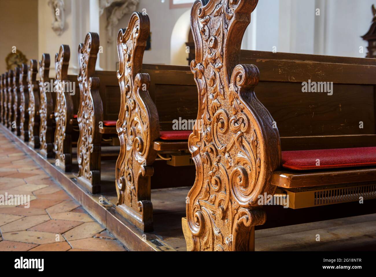 Leere Bänke in der Kirche, Nahaufnahme, geschnitzte Holzbänke in der katholischen Kathedrale, Detail der christlichen Kirche innen. Wunderschöne alte Bänke, Gebetsbänke Stockfoto