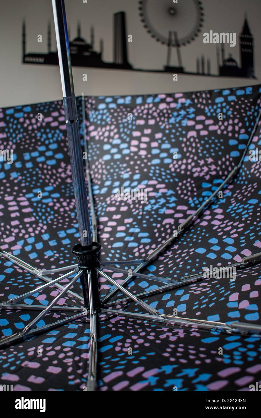 Farbenfroher Regenschirm mit Pfeil-nach-oben- und Pfeil-nach-unten-Taste auf einem Holztisch im Haus Stockfoto