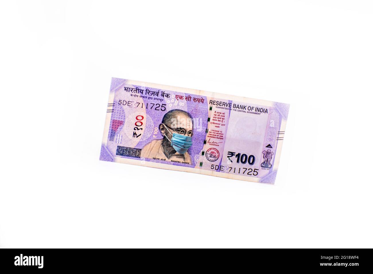 Mahatma Gandhi mit Gesichtsmaske gegen Coivd-19-Infektion. Die Weltwirtschaft ist vom Ausbruch des Corona-Virus betroffen. Stockfoto