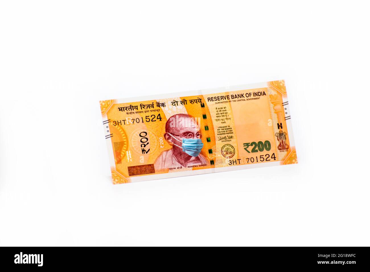 Mahatma Gandhi mit Gesichtsmaske gegen Coivd-19-Infektion. Die Weltwirtschaft ist vom Ausbruch des Corona-Virus betroffen. Stockfoto