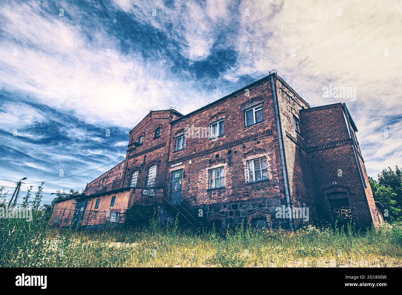 Monumentales Lost Place Horrorhaus in krafttigen Farben. Verlassenes Gebäude mitten im Niergendwo getarnt als alte, stillgelegte Brauerei und Fabrik Stockfoto