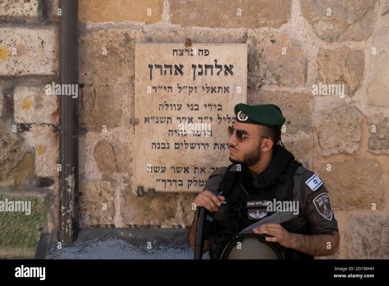 Ein israelischer Grenzpolizist steht Wache vor einer Gedenktafel für Elhanan Aharon, einen jungen jüdischen Studenten in der 'Ateret Cohanim' Yeshiva, der 1991 von Palästinensern ermordet wurde, während er auf der El Wad, auch Hagai Straße in der Altstadt von Jerusalem genannt, ging. Israel Stockfoto