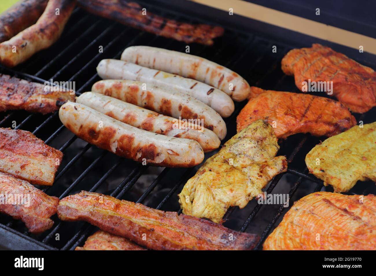 Verschiedene Fleisch- und Wurstwaren auf dem Holzkohlegrill Stockfoto