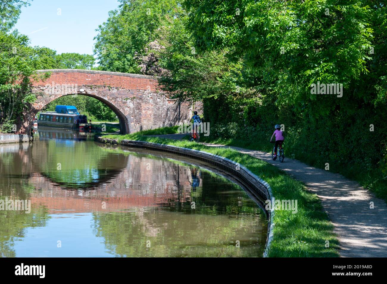 Fahrradtour mit der Familie durch die englische Landschaft entlang des Kanals bei strahlendem Sonnenschein an einem Sommertag. Vergeht Zeit im glorreichen Juni. Stockfoto