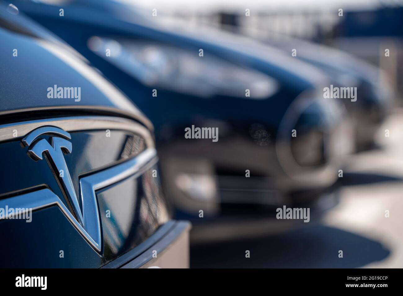 Tesla Elektrofahrzeuge mit Abzeichen im Vordergrund Stockfoto